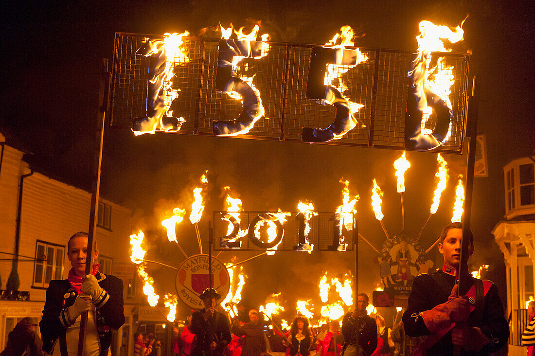 Menschen mit brennenden Bannern zum Gedenken an die protestantischen Märtyrer, die 1556 in Mayfield, East Sussex, Großbritannien verbrannt wurden