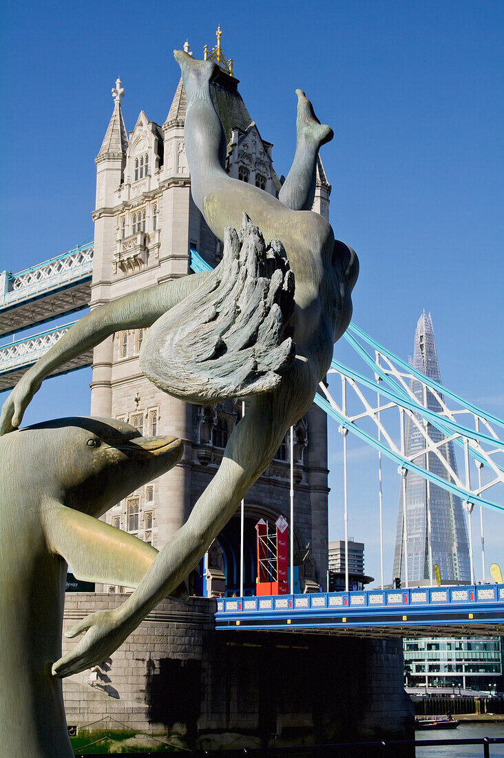 Vereinigtes Königreich, Shard-Gebäude im Hintergrund; London, Mädchen mit Delphin-Statue vor der Tower Bridge