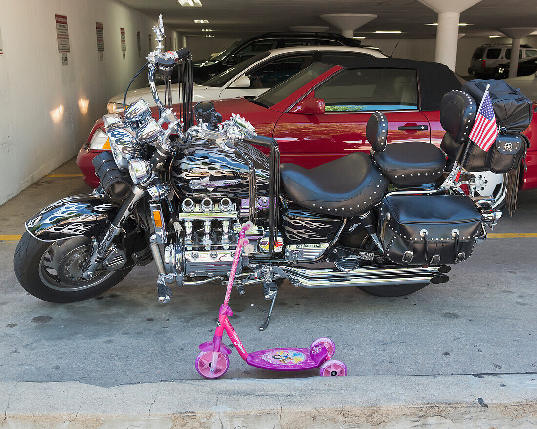 USA, Colorado, Großes glänzendes Motorrad geparkt neben einem Kinderroller; Denver