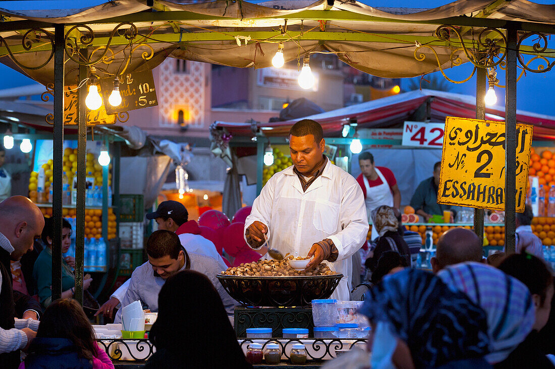 Marokko, Mann verkauft gekochte Schnecken an einem Stand auf dem Djemaa el-Fna; Marrakesch