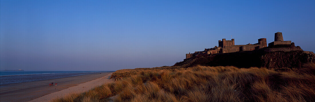 Uk, England, Northumberland, Northumbrian Coast, Panoramic View Of Sunset Over Bamburgh Castle And Beach; Bamburgh