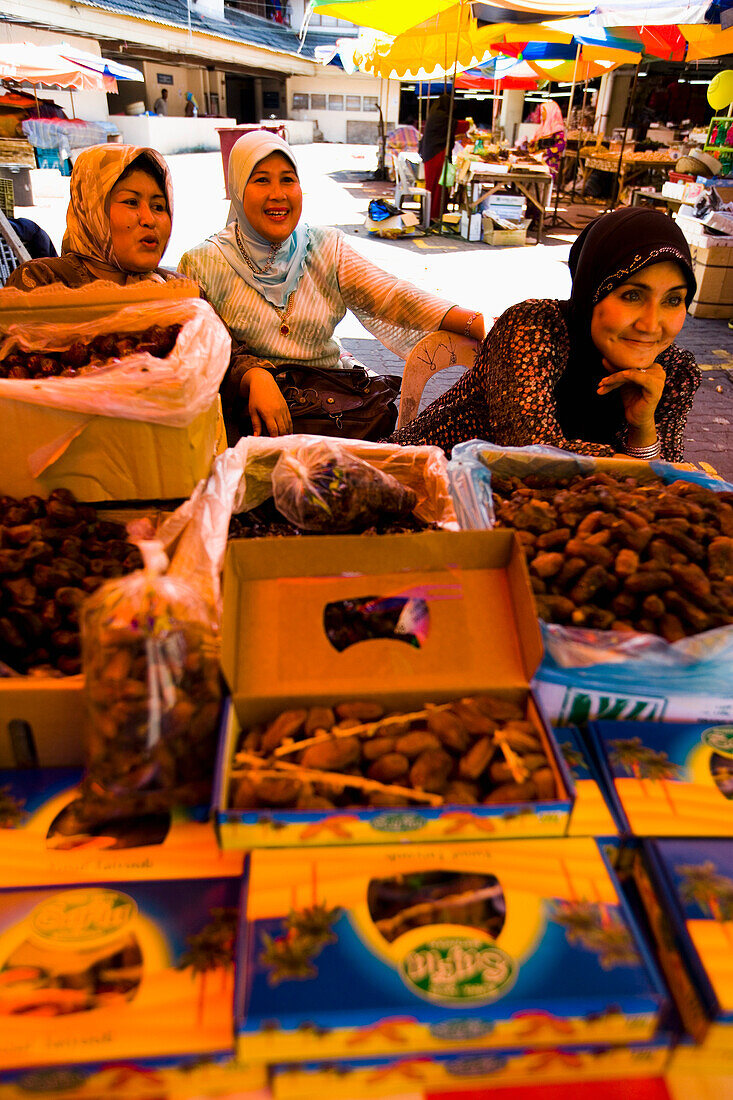 Malaysia, Terengganu, Pasar Payang Zentraler Markt; Kuala Terengganu, Standbetreiberinnen verkaufen Datteln auf einem großen Markt im Innen- und Außenbereich