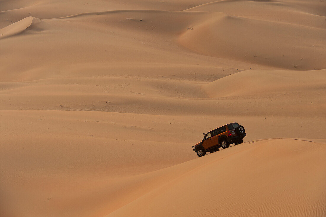 UAE, Abu Dhabi, Four wheel drive going across sand dunes; Liwa