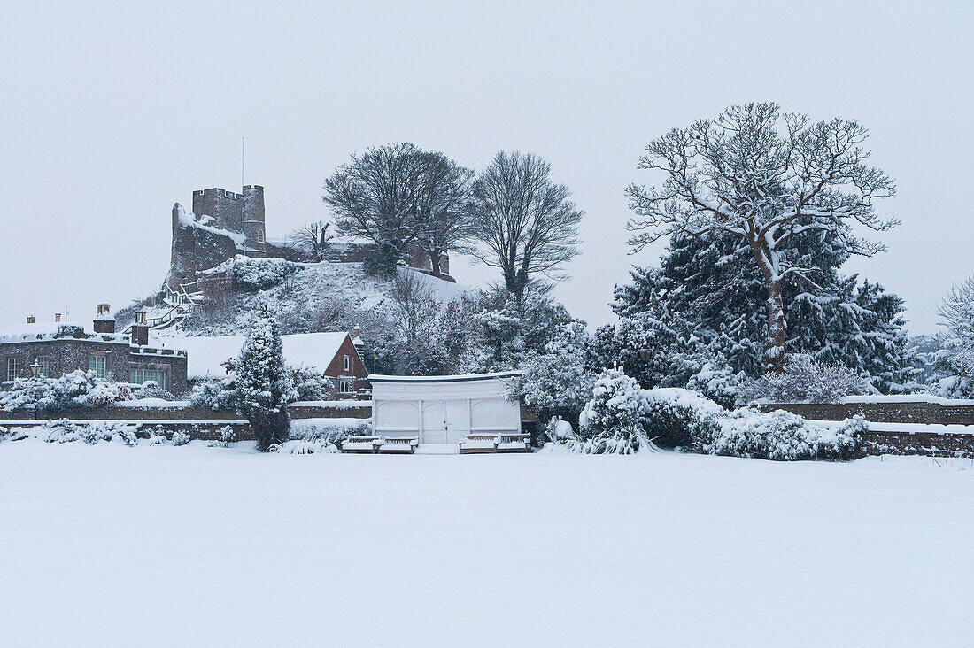 UK, East Sussex, Looking across bowling green to castle covered in snow; Lewes