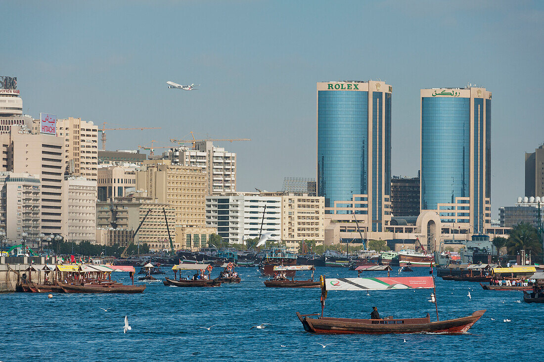 Dubai, Uaewater Taxis At The Creek With Plane Taking Off In Background