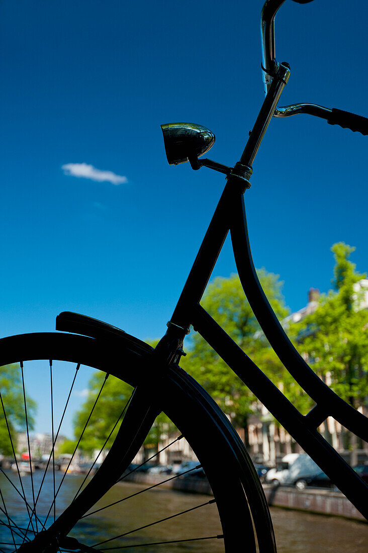 Silhouette eines Fahrrads vor einem Kanal,Amsterdam, Holland.