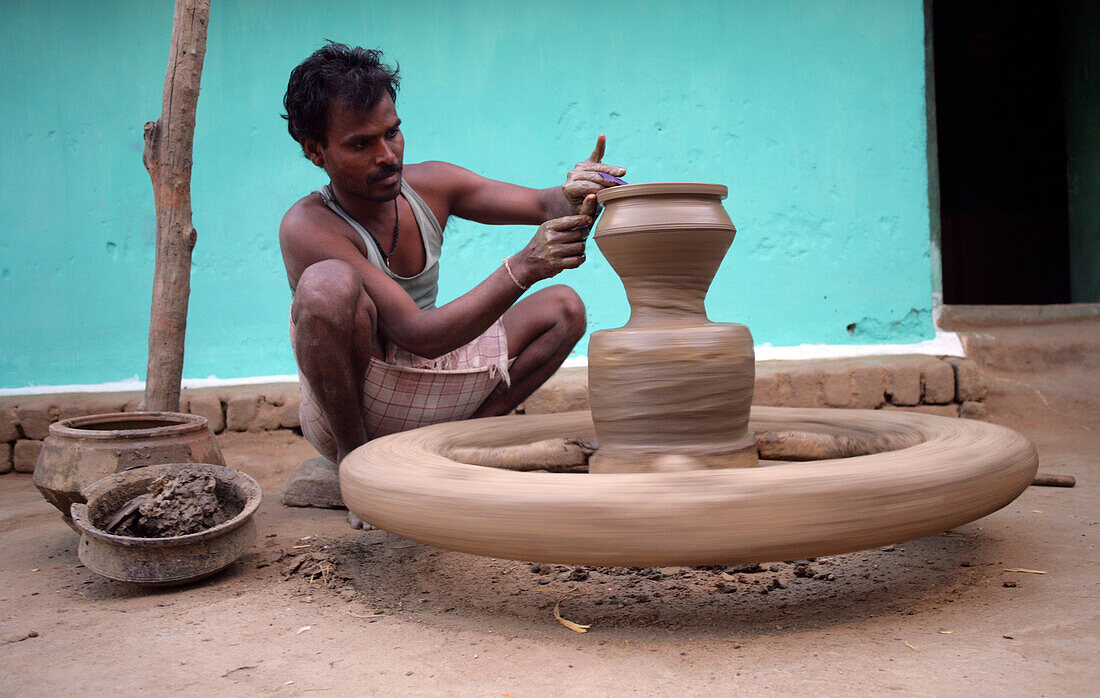 Ein Mann arbeitet an einer Töpferscheibe, Töpferdorf; Madhya Pradesh, Indien