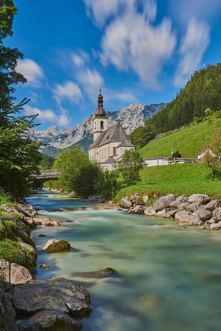 Pfarrkirche St. Sebastian mit der Ramsauer Ache, die durch das Tal fließt, nördlich des Nationalparks Berchtesgaden; Berchtesgadener Land, Ramsau, Bayern, Deutschland