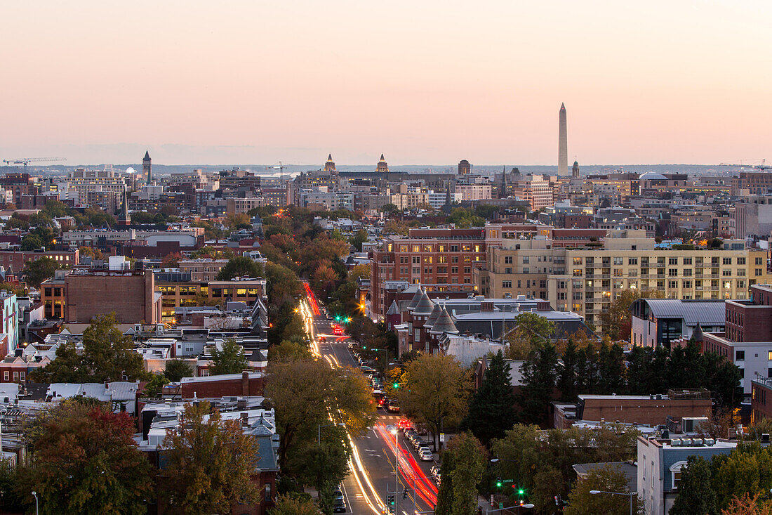 A view of the skyline lit with traffic lights at sunset, and the Washington Monument.; Washington, District of Columbia, United States of America