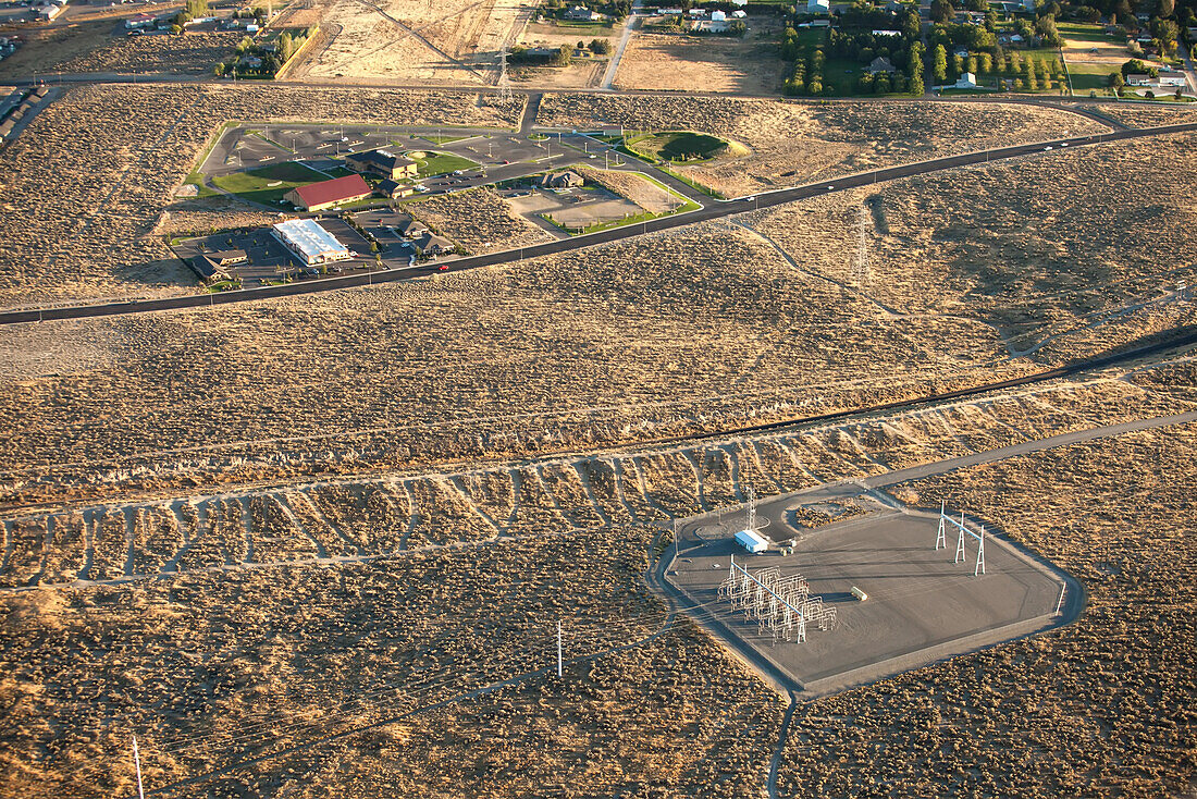 Electrical distribution and power lines in an arid landscape near urban developments.; Richland, Washington