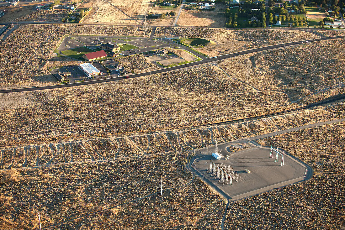 Stromverteilungs- und Stromleitungen in einer trockenen Landschaft in der Nähe städtischer Siedlungen; Richland, Washington