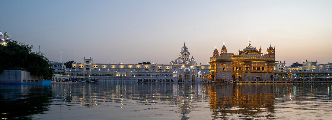 Der Goldene Tempel (Sri Harmandir Sahib) Gurdwara und Sarovar (Nektarbecken), in der Abenddämmerung; Amritsar, Punjab, Indien