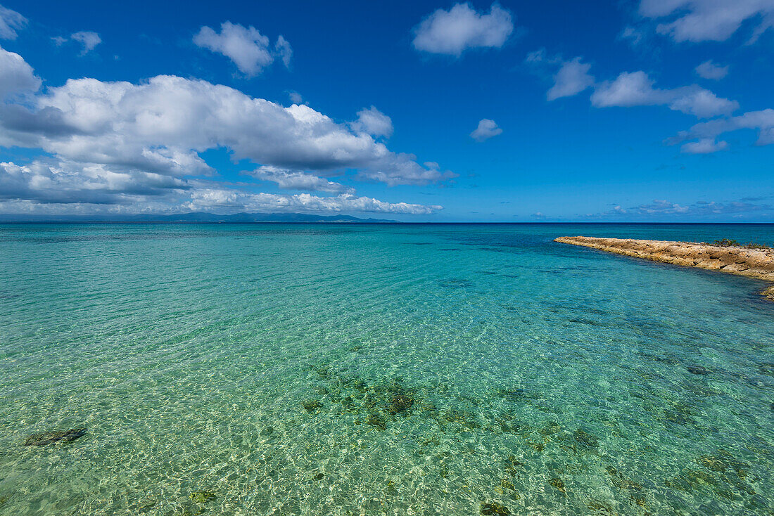 Blue sky and turquoise water of the Caribbean Sea at the end of the rocky waterfront in Port-Louis on Grande-Terre; Guadeloupe, French West Indies