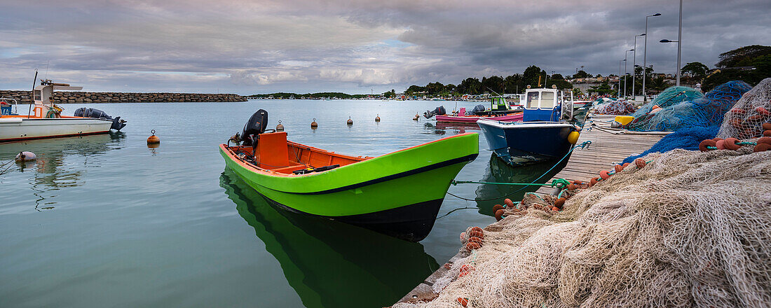 Motorboote und Fischerboote am Kai vertäut, aufgestapelt mit Fischernetzen im Hafen von Sainte Rose auf Basse-Terre; Guadeloupe, Französisch-Westindien