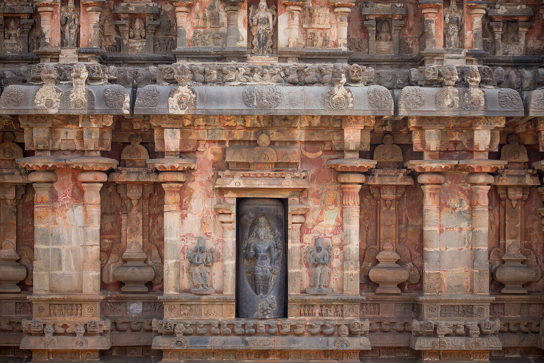 Nische mit Schnitzerei einer Hindu-Gottheit in der Steinwand des Airavatesvara-Tempels aus der dravidischen Chola-Zeit; Darasuram, Tamil Nadu, Indien