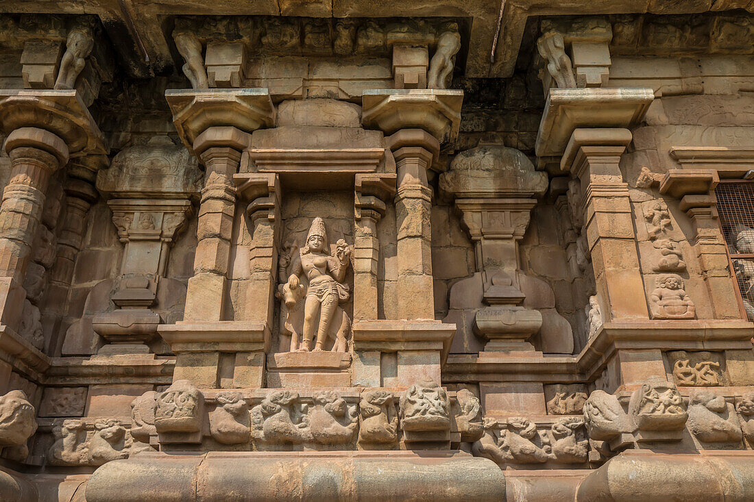 Nische mit Hindu-Gottheit in Steinmauer des Airavatesvara-Tempels aus der dravidischen Chola-Zeit mit Säulen und Reliefs; Darasuram, Tamil Nadu, Indien
