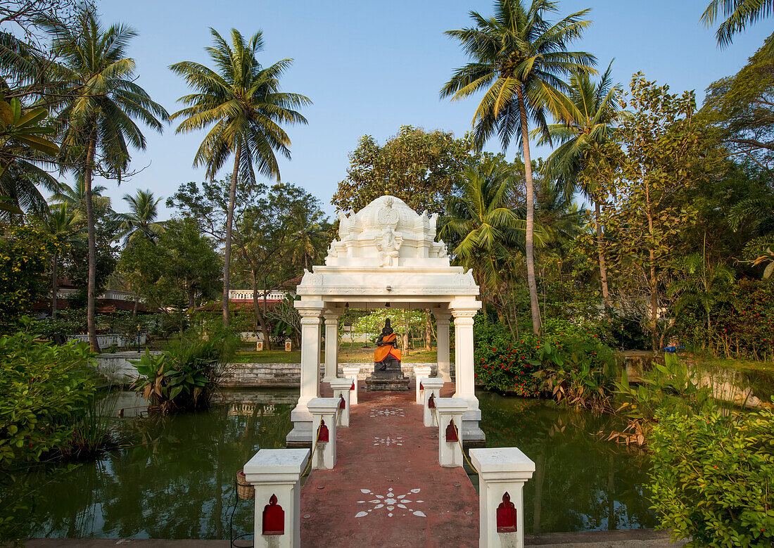 Hindu-Schrein mit einer in orangefarbene Seide eingewickelten Götterstatue in einem ländlichen Dorf auf dem CGH Earth-Gelände von Mantra Koodam in Kumbakonam; Tamil Nadu, Indien