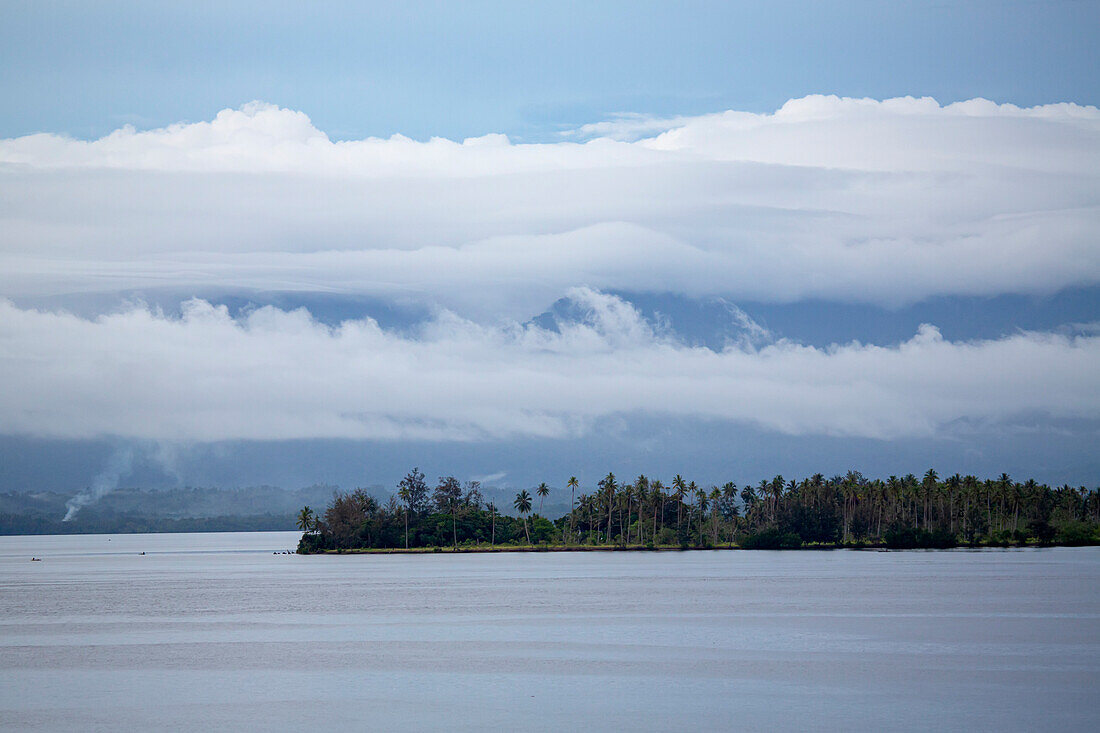 Mist over the island jungles of Dobu in the D'Entrecasteaux Islands, Papua New Guinea; Dobu Island, D'Entrecasteaux Islands, Papua New Guinea