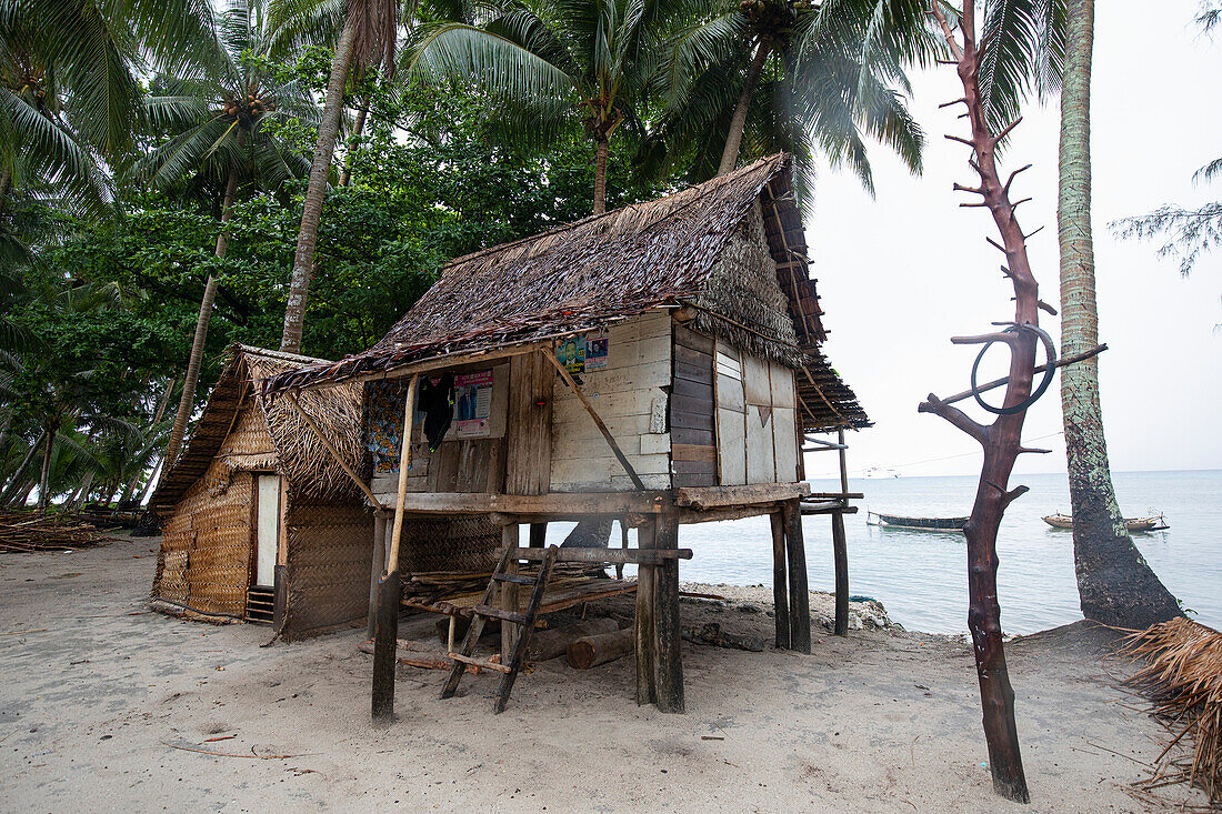 Village home hut on stilts with thatched roof on Kuiawa Island; Kuiawa Island, Trobriand Islands, Papua New Guinea