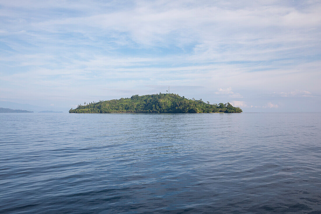Mit Dschungel bewachsene tropische Insel mit G4-Mobilfunkmast in der Salomonen-See vor der Provinz Morobe; Papua-Neuguinea