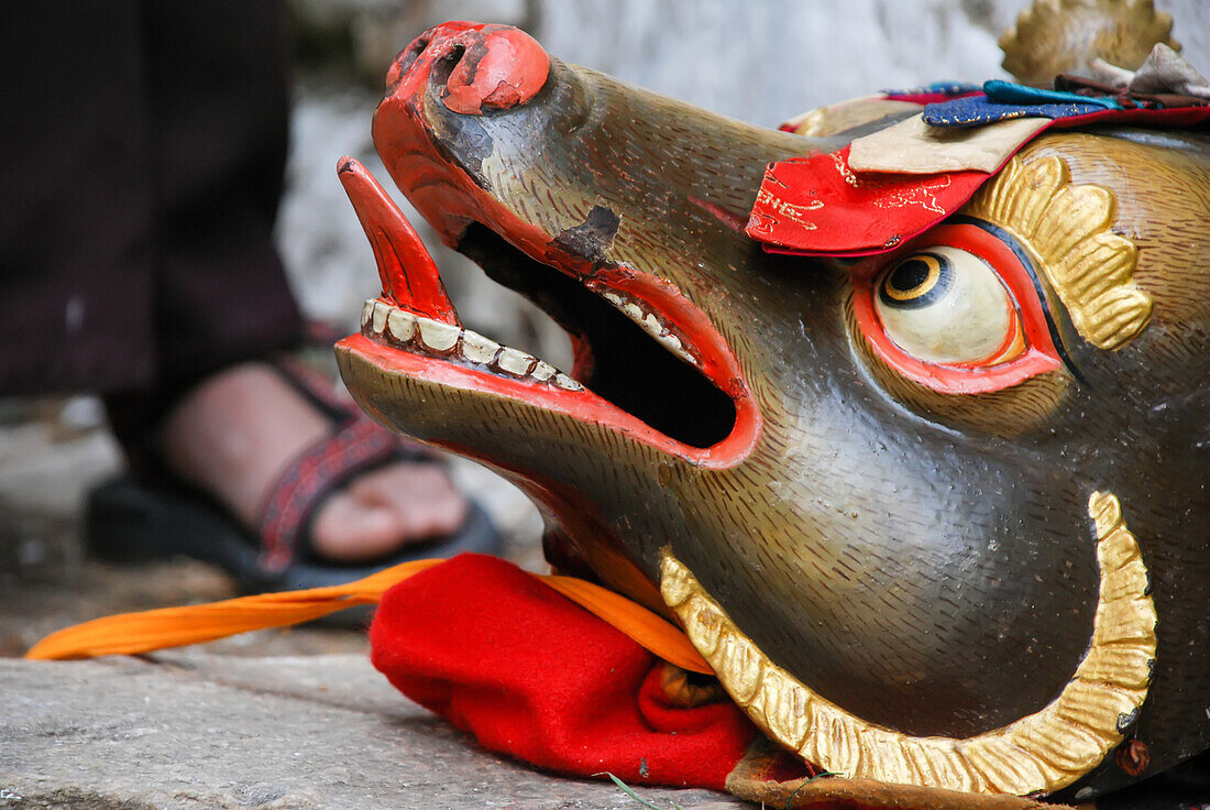 A mask used in the Paro Tshechu Festival rests on the ground within Paro Dzong, a monastery and fortress.; Paro, Bhutan
