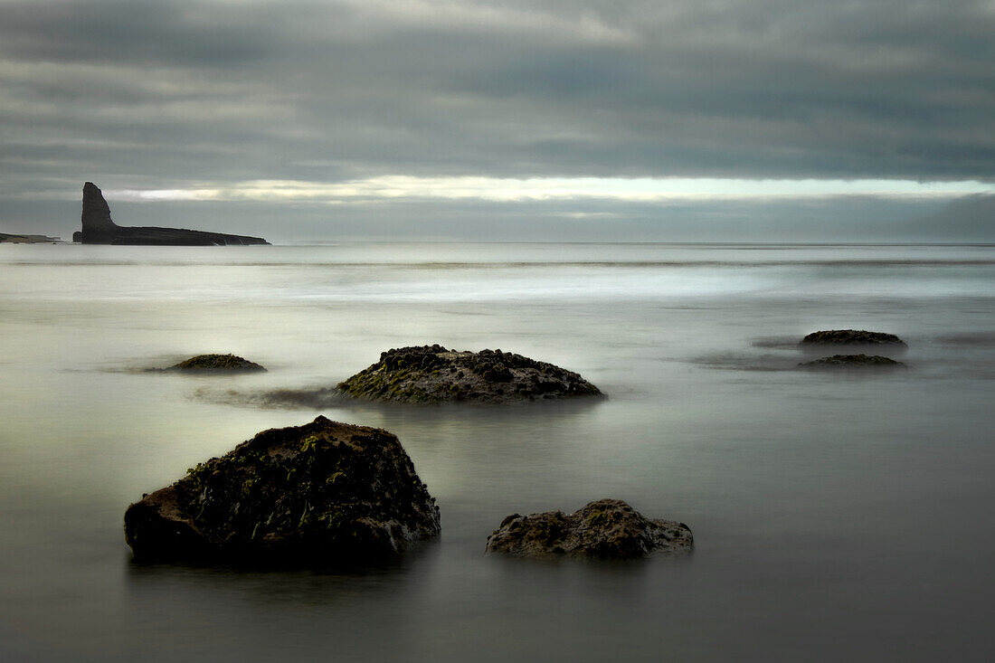 Rock formations emerge from the water along the coast at Four-Mile Beach at Wilder Ranch State Park, Central Coast; Santa Cruz, California, United States of America