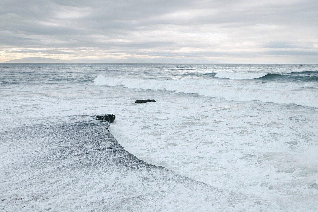 Wellen brechen gegen das Felsplateau entlang der felsigen Küste in Santa Cruz; Santa Cruz, Kalifornien, Vereinigte Staaten von Amerika