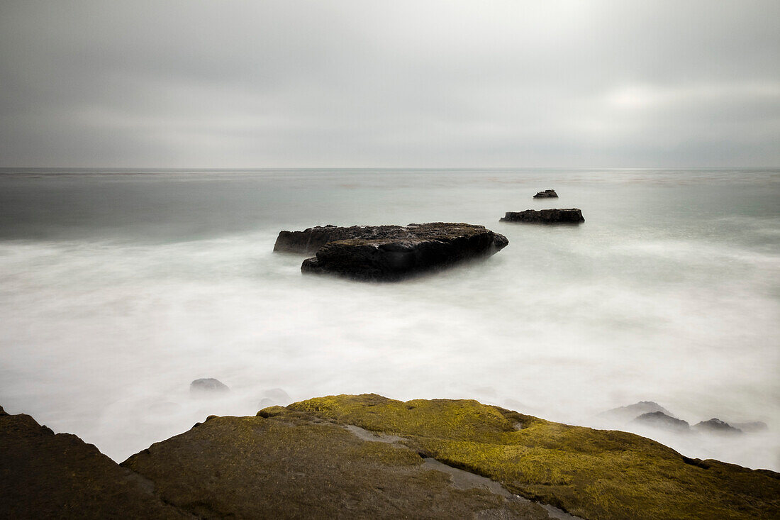 Eine lang belichtete Meereslandschaft entlang eines felsigen Strandes in Santa Cruz; Santa Cruz, Kalifornien, Vereinigte Staaten von Amerika