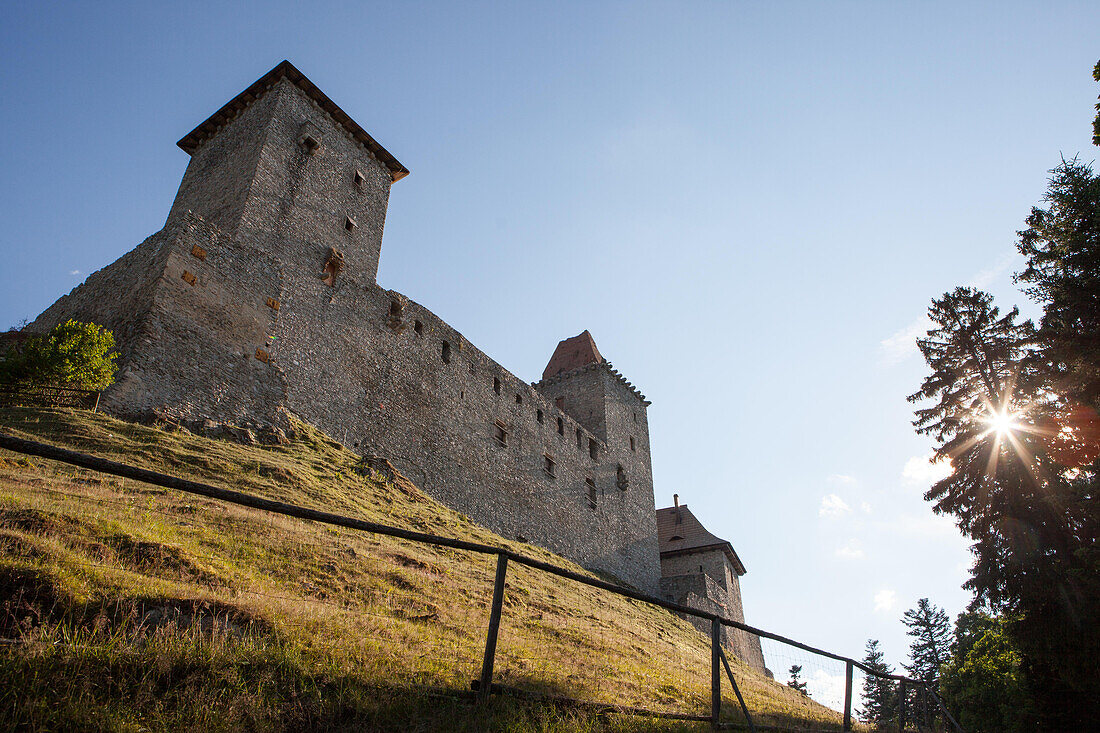 Das Schloss Kasperk liegt auf einem Hügel, während die Sonne durch die Bäume im Böhmerwald von Sumava bricht; Schloss Kasperk, Böhmerwald, Böhmerwald, Tschechische Republik