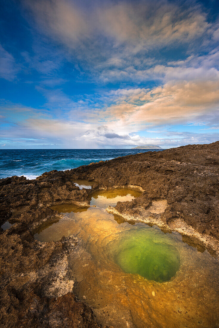 Vulkanische Felsformationen und Sonnenlicht, das sich im grünen Gezeitentümpel am Strand von Pointe des Chateaux spiegelt; Grande-Terre, Guadeloupe, Französisch-Westindien