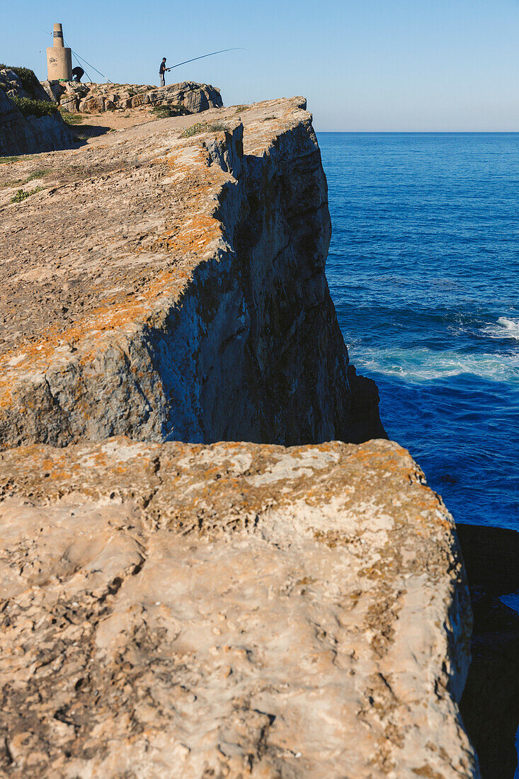 Angeln von einer hohen Klippe an der Küste bei Papoa, Portugal; Papoa, Peniche, Oeste, Portugal