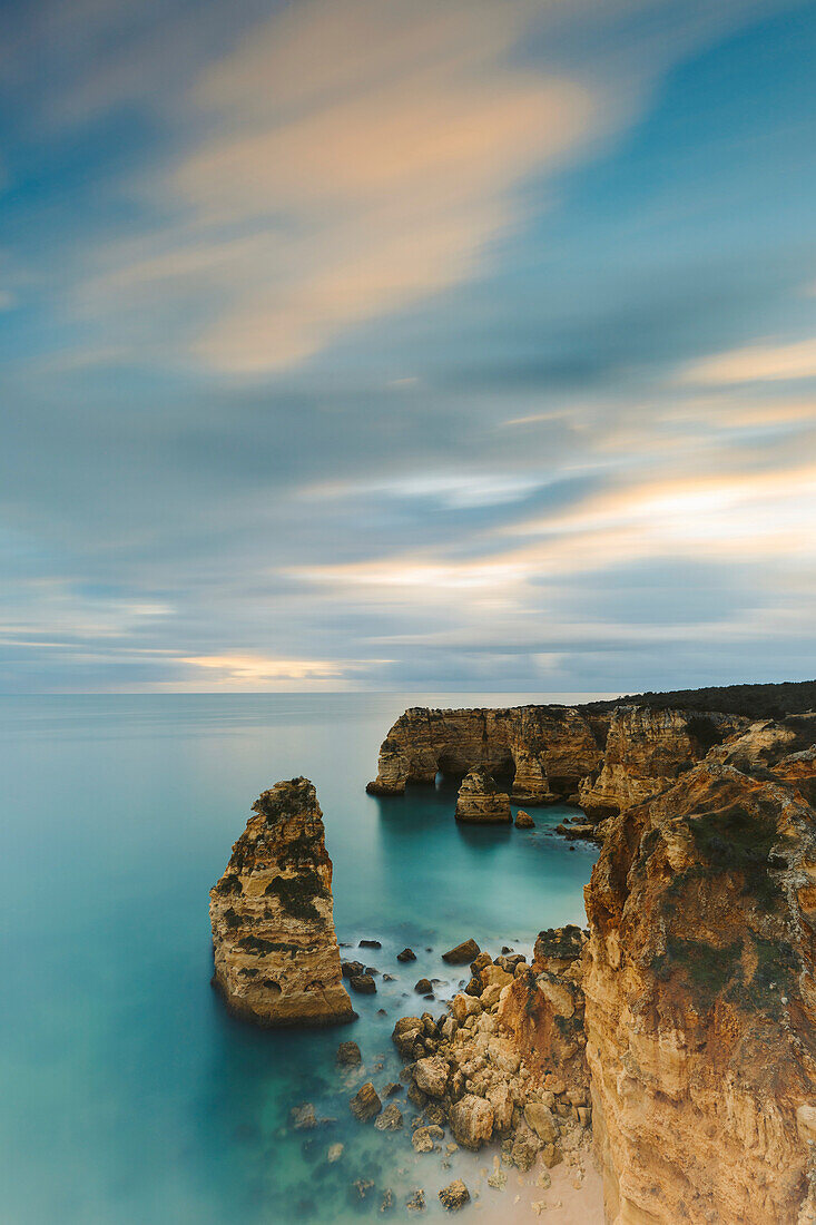 Coastal rock formations and turquoise water of the Atlantic Ocean along the rugged coast of the Algarve Region; Algarve, Portugal
