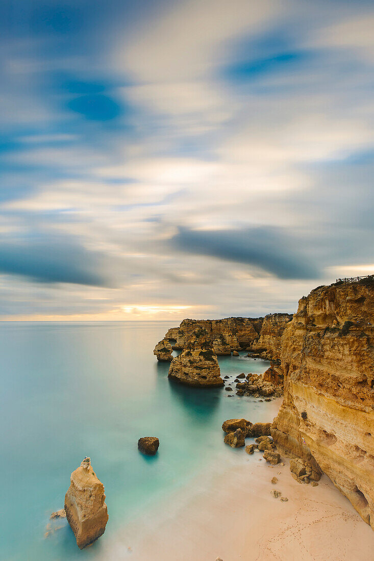 Coastal rock formations and turquoise water of the Atlantic Ocean along the rugged coast of the Algarve Region; Algarve, Portugal