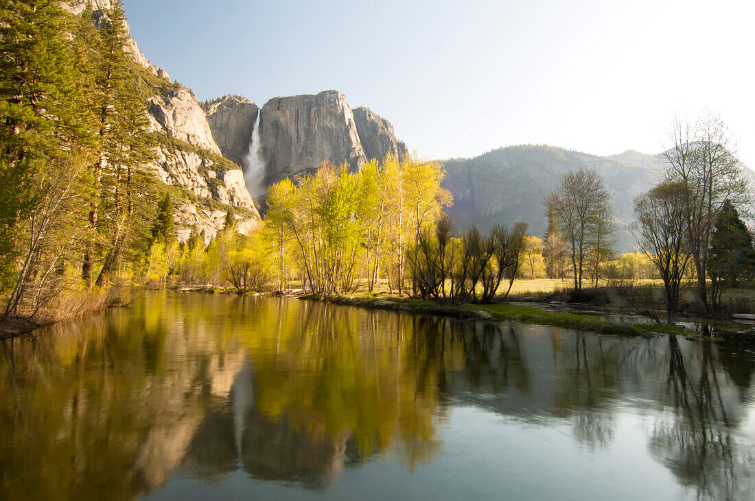 Yosemite Falls and autumn foliage reflected in Merced River, Yosemite National Park; California, United States of America