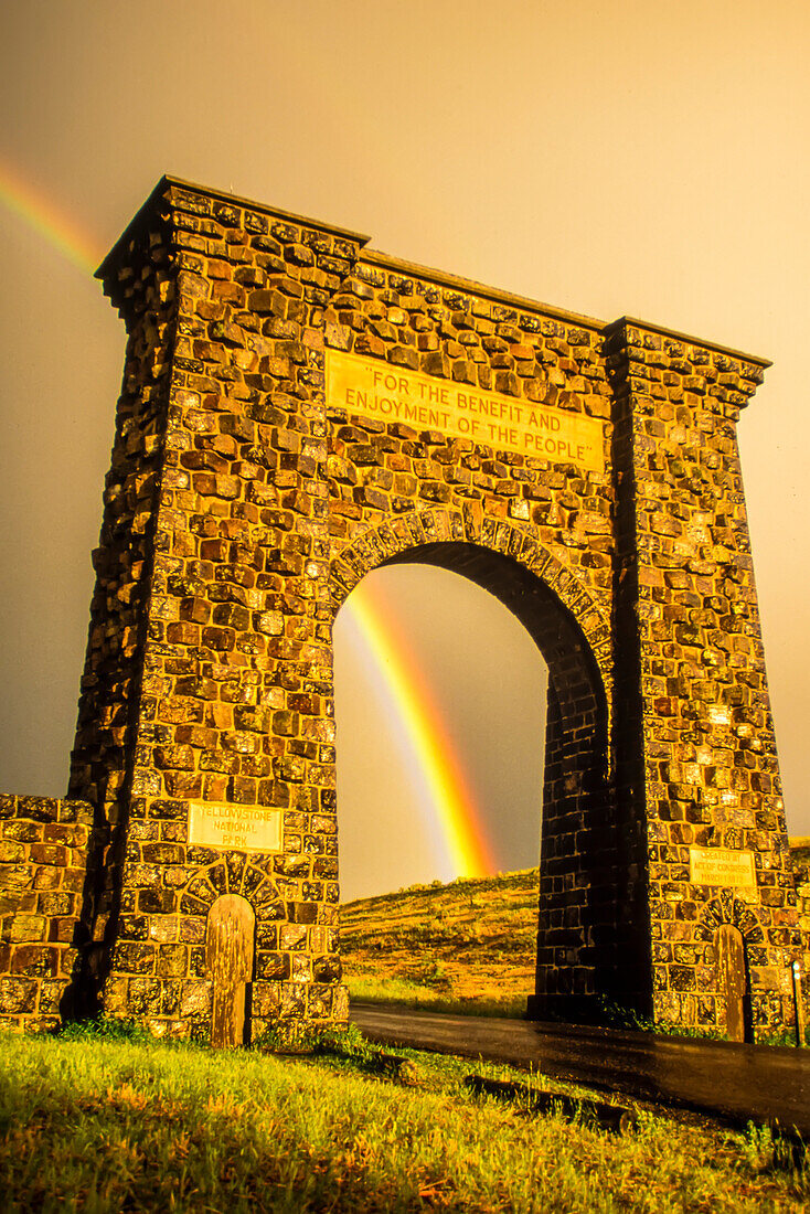 Roosevelt Arch mit einem atemberaubenden Regenbogen am Nordeingang zum Yellowstone National Park in Gardiner; Montana, Vereinigte Staaten von Amerika