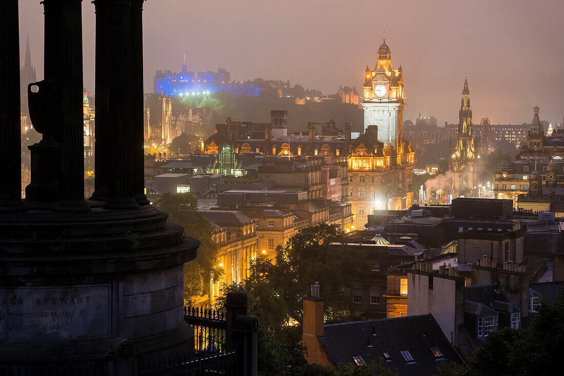 The tower of the Balmoral Hotel, the Edinburgh Castle and downtown Edinburgh, Scotland are illuminated at dusk as seen from Calton Hill; Edinburgh, Scotland