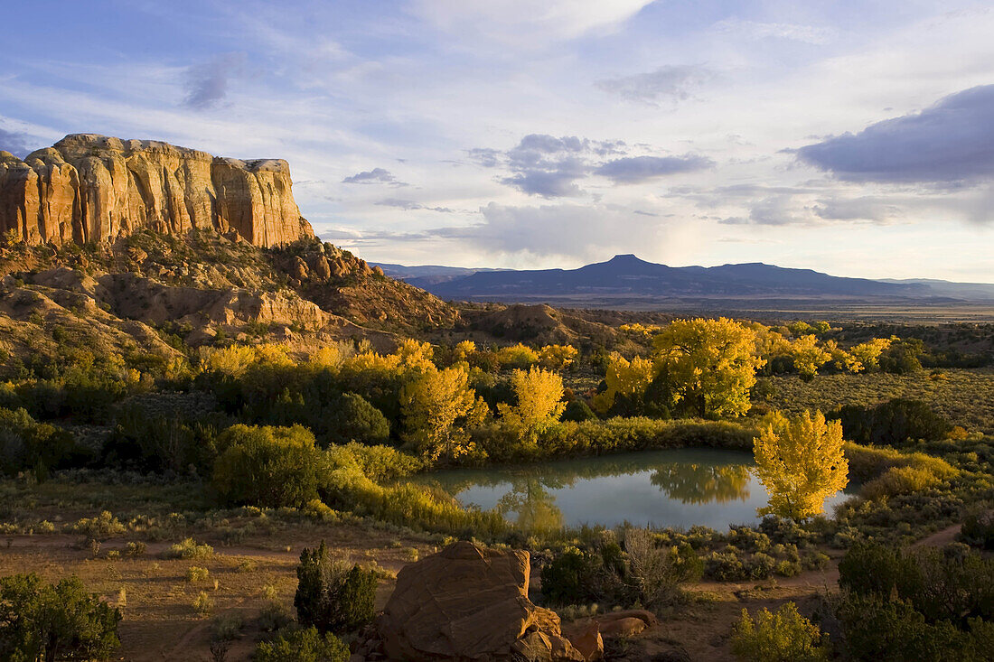 Ein Teich ist neben der Kitchen Mesa zu sehen, mit dem Pedernal Peak in der Ferne