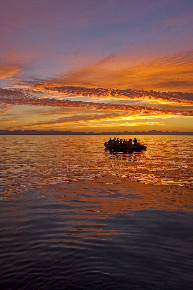 Touristen in einem Schlauchboot bei Sonnenuntergang auf dem Canal de Ballenas.