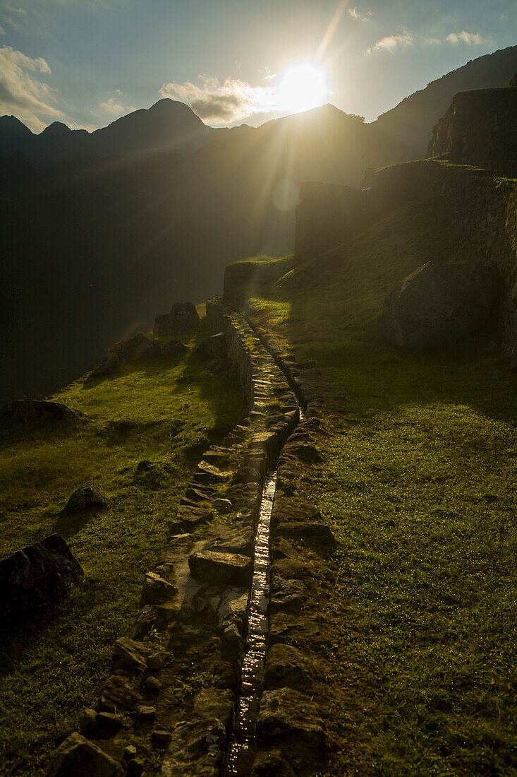 Sonnenaufgang auf einem präkolumbianischen Inka-Aquädukt in Machu Picchu.