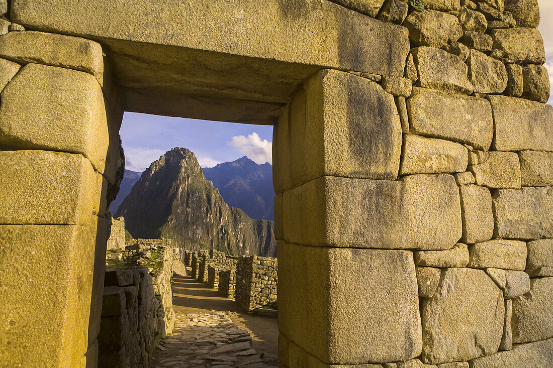 Huayna Picchu peak seen through stone doorway in Machu Picchu.