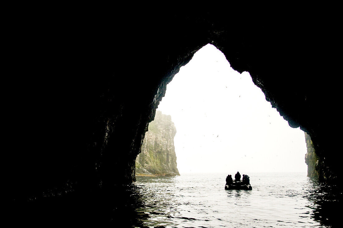 Men in inflatable boat explore Bear Island in the Barents Sea.