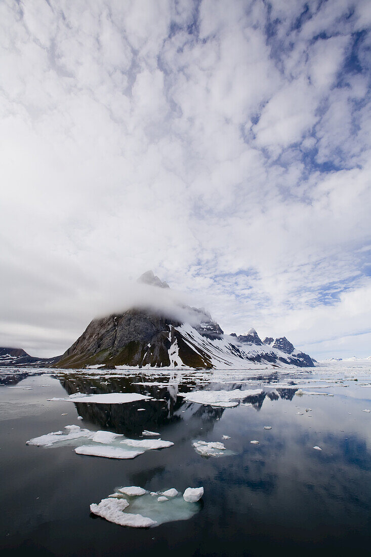 Clouds are reflected in clear arctic waters.