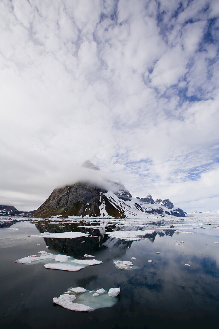 Wolken spiegeln sich in klaren arktischen Gewässern.