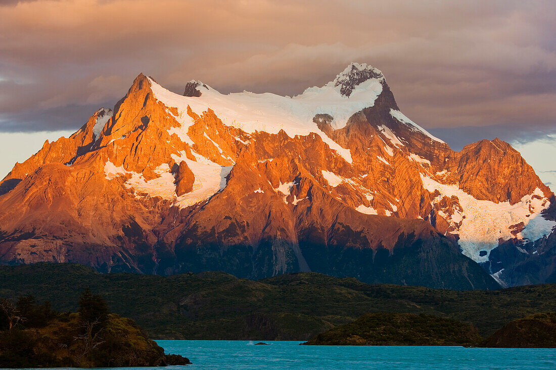 Snow-covered mountain peaks of the Torres del Paine mountains and Lago (Lake) Pehoe at sunrise, Torres del Paine National Park; Patagonia, Chile
