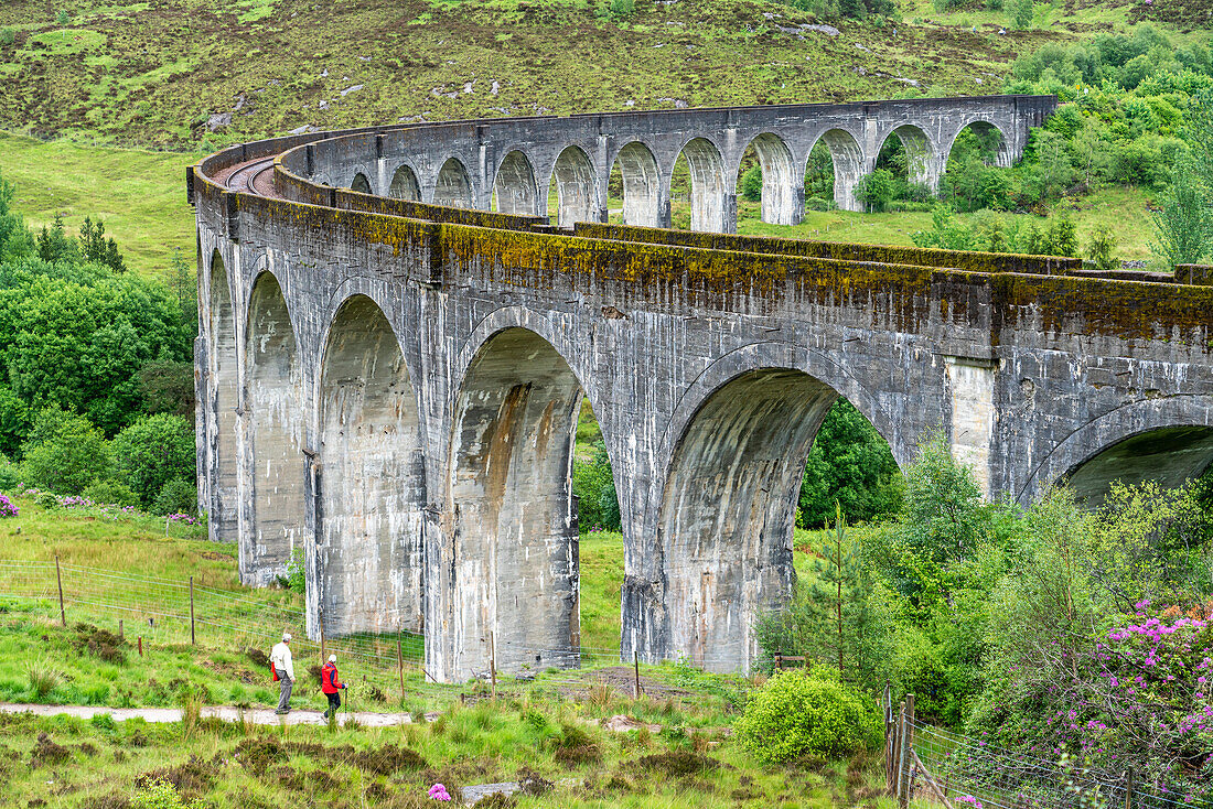 Zwei Wanderer gehen in Richtung des Viadukts bei Glenfinnan, Schottland; Glenfinnan, Inverness-shire, Schottland