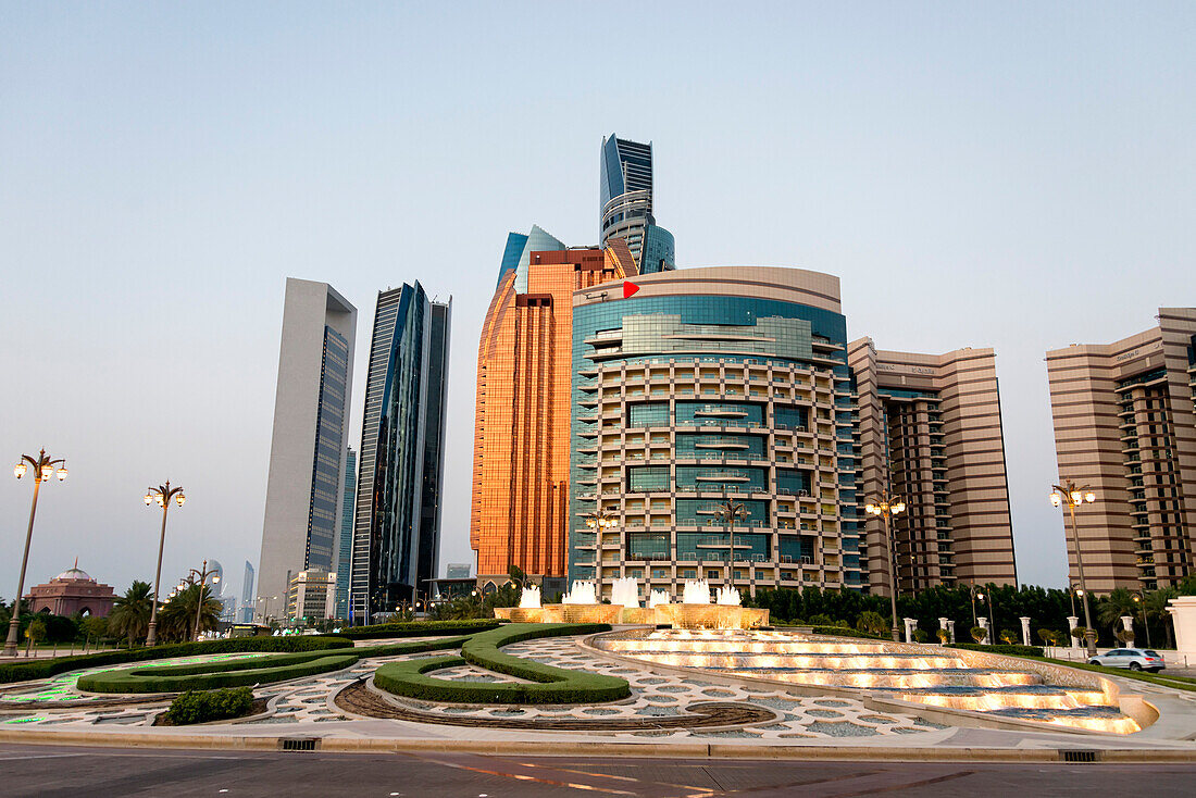 Springbrunnen vor dem Khalidiya Palace Rayhaan by Rotana mit dem Bab AlQasr Hotel und den Etihad Towers im Hintergrund; Abu Dhabi, Vereinigte Arabische Emirate