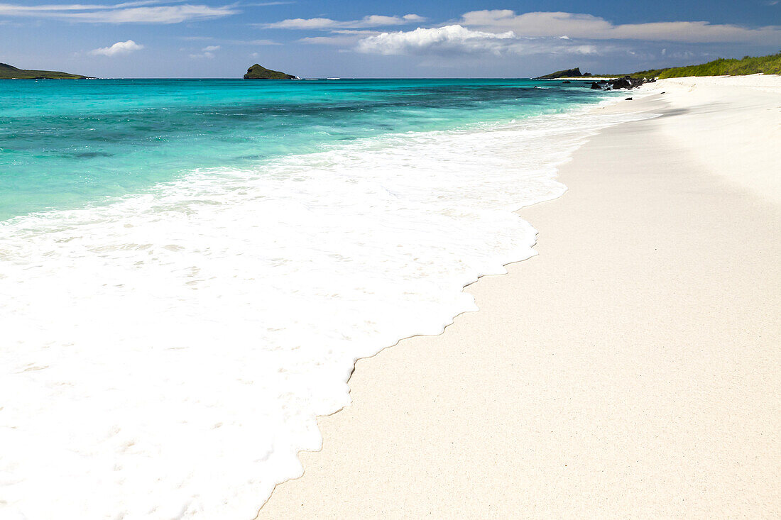 Brandung an einem weißen Korallensandstrand.