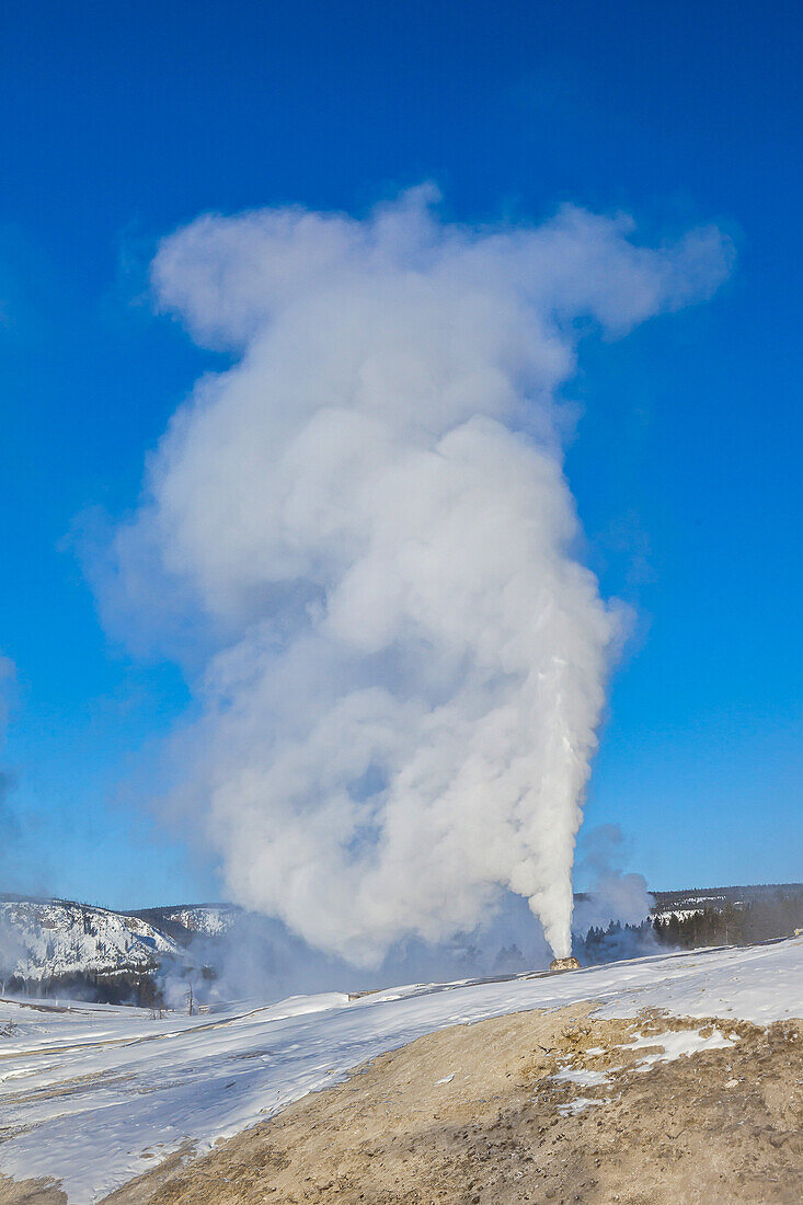 Steam rises from a large natural geyser.