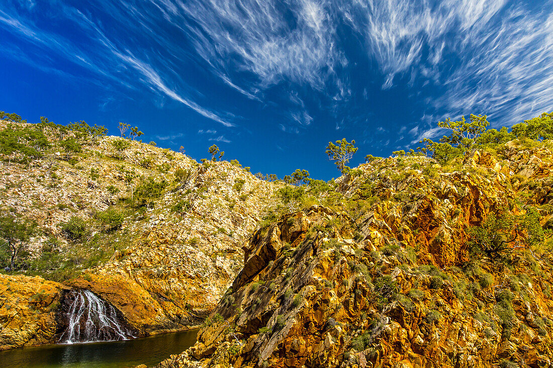 A low angle view of Cirrus clouds above a cliff near Crocodile Creek in the Kimberley Region of Northwest Australia.