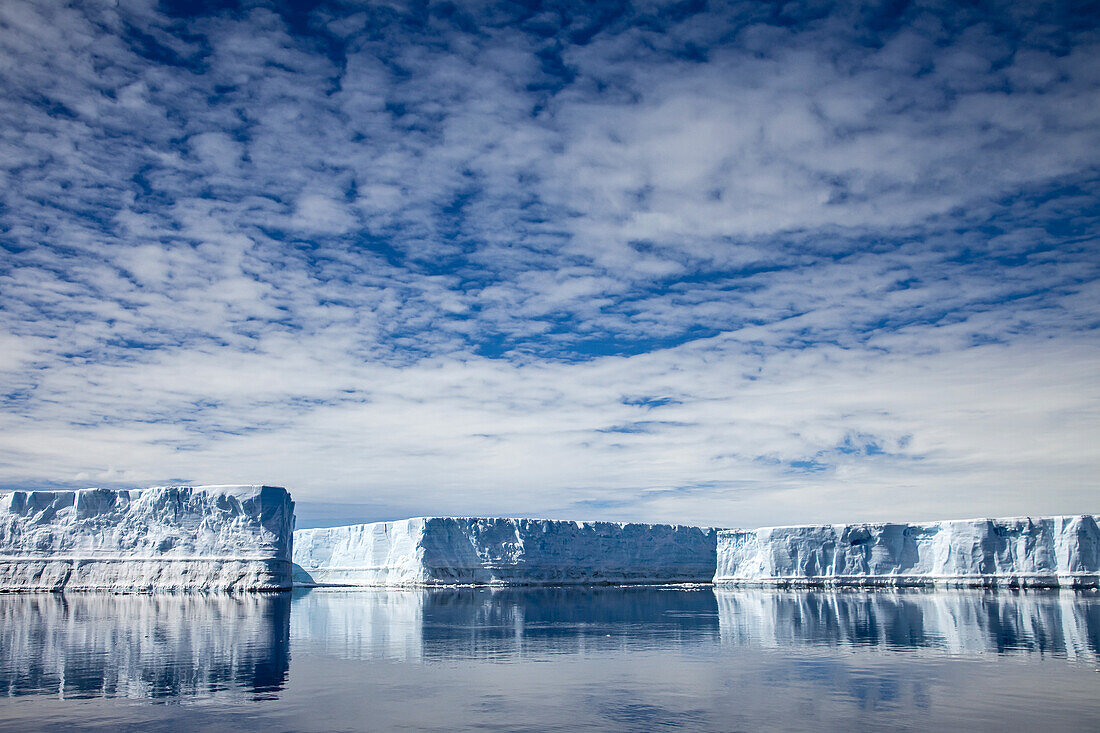 Tabular iceberg lined up in the ocean.
